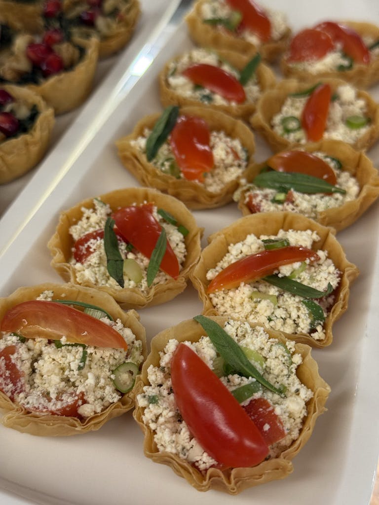 Delicious tomato and cheese tartlets garnished with herbs, perfect for appetizers.